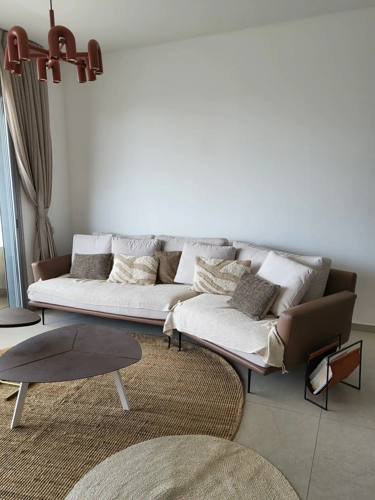 Bright designer living room with curved sofa and chandelier