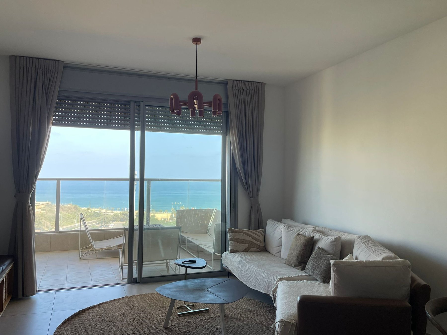Living room with floor-to-ceiling windows and sea view