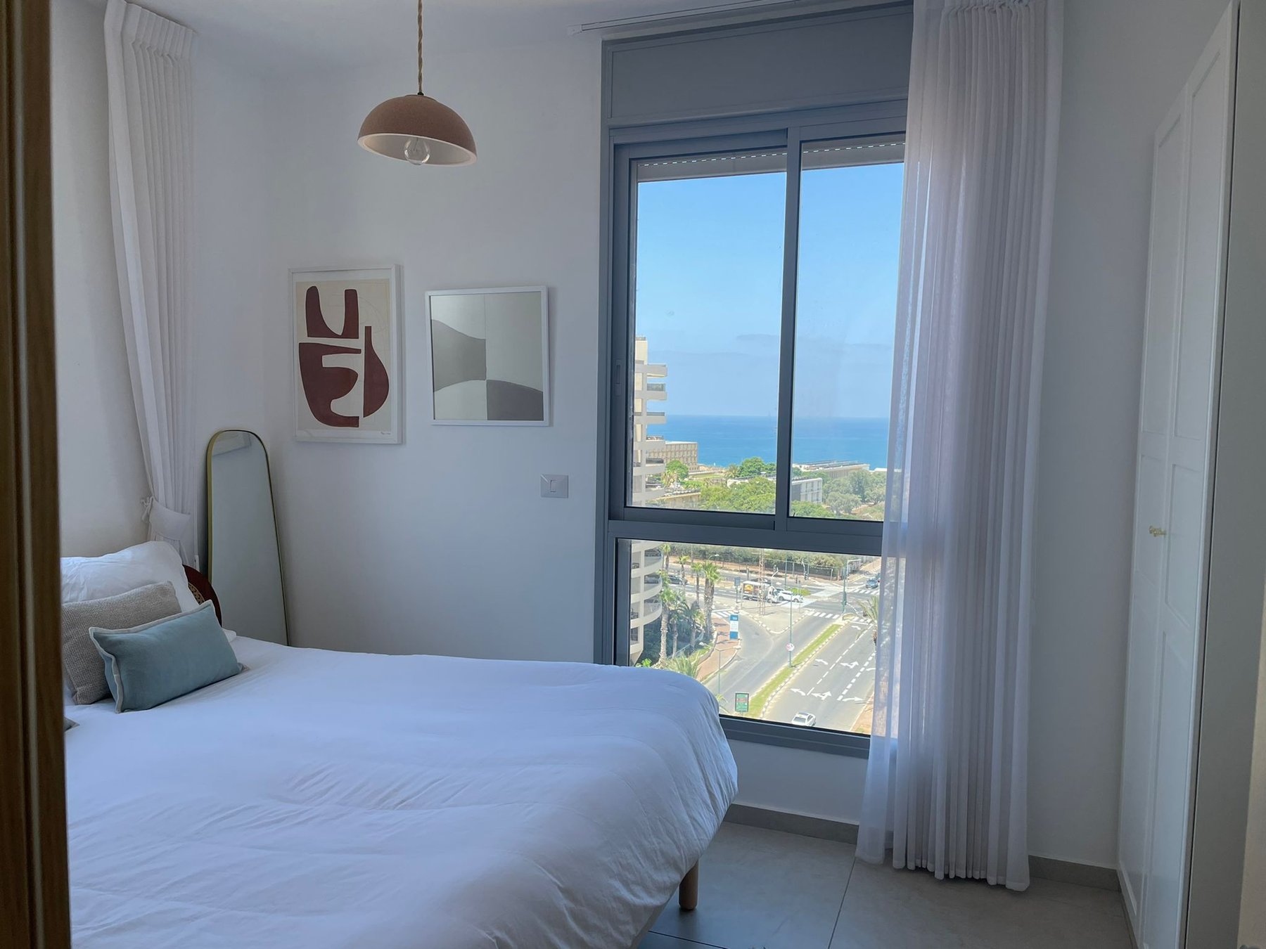 Second bedroom with sea-view window and blue accents